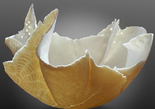 Eine kunstvolle Schale aus Porzellan mit einem wellenformigen, teils spitzem, Rand.