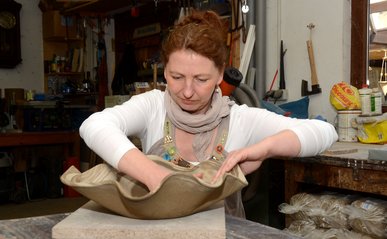 Doreen Neumann fertigt eine wellenförmige Schale aus Ton.