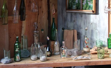 Verschieden gestaltete Flaschenkunstwerke stehen nebeneinander an einem Stand.